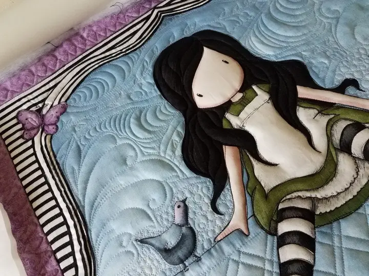 Custom figure quilt of a mermaid, free-motion stitched in teal and cream