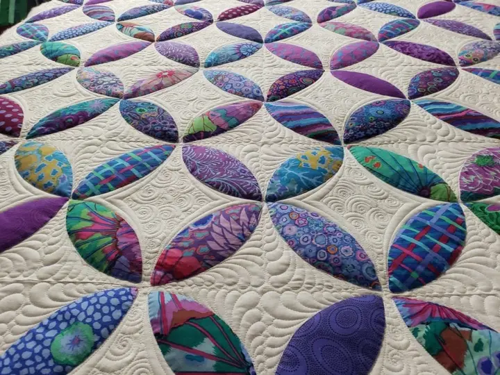 Interlocking ring quilt in teal, purple and magenta, densely filled